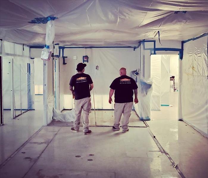 Two male technicians outside containment