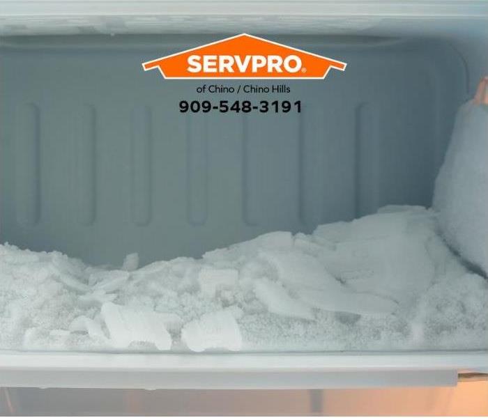 A refrigerator’s freezer is clogged with ice buildup.
